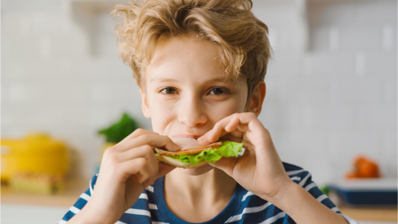 Jeune garçon mangeant une sandwich